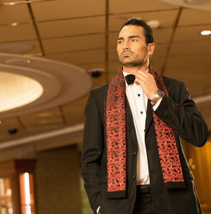 Modelo elegante com terno e lenço vermelho em evento social, representando estilo e sofisticação.